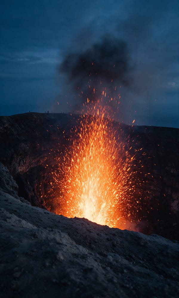 Orange lava arcing from the vent at Mount Yasur's crater rim on Tanna at dusk