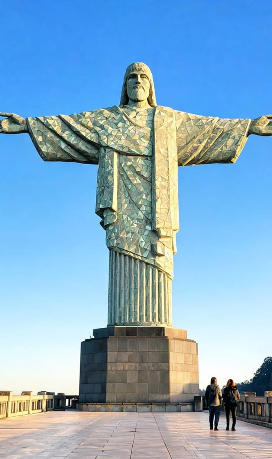 Cristo Redentor standing above Rio de Janeiro with visitors at its base