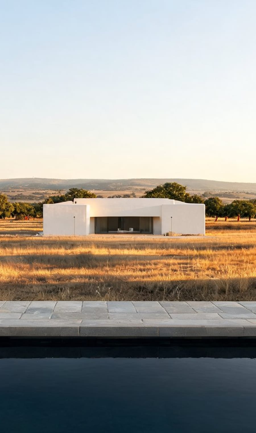 A low white building and reflecting pool on the open plain of the Alentejo