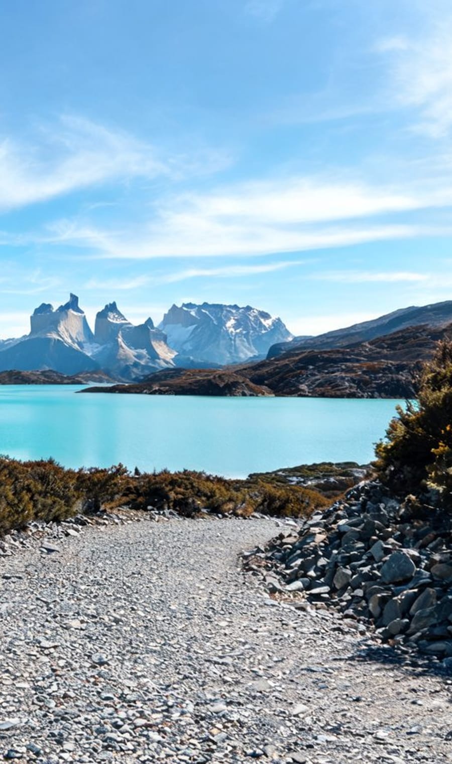 The gravel W Trek trail above a turquoise lake below the Torres del Paine