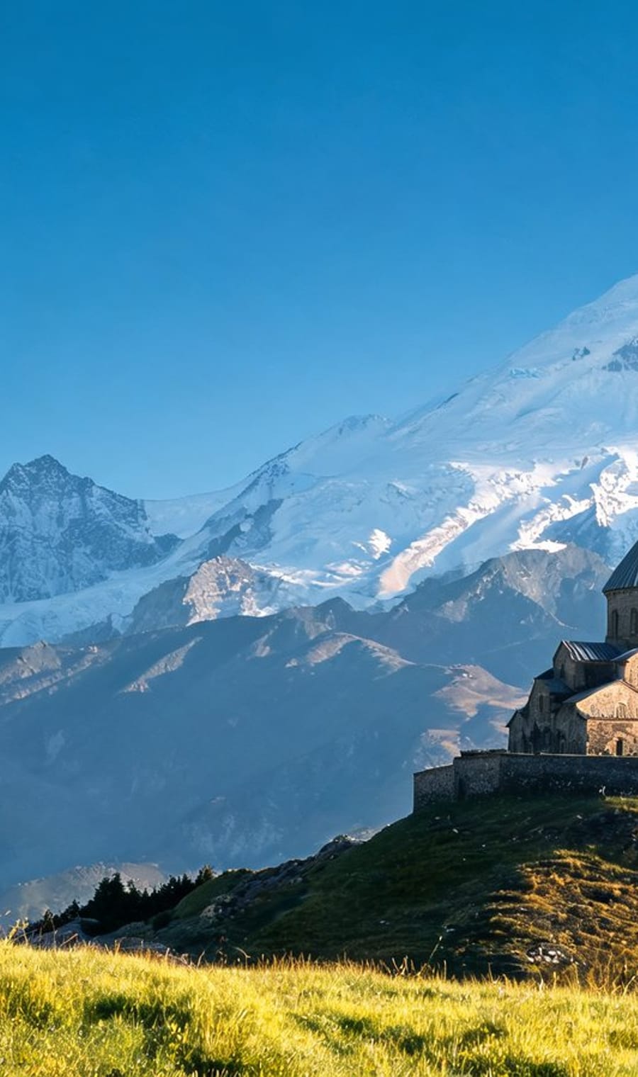 Gergeti Trinity church on its ridge below the snows of Kazbegi, Georgia