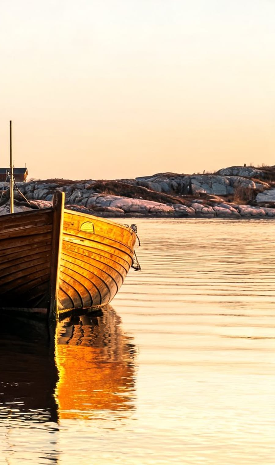 A wooden boat on still water at Ilulissat in Disko Bay, Greenland