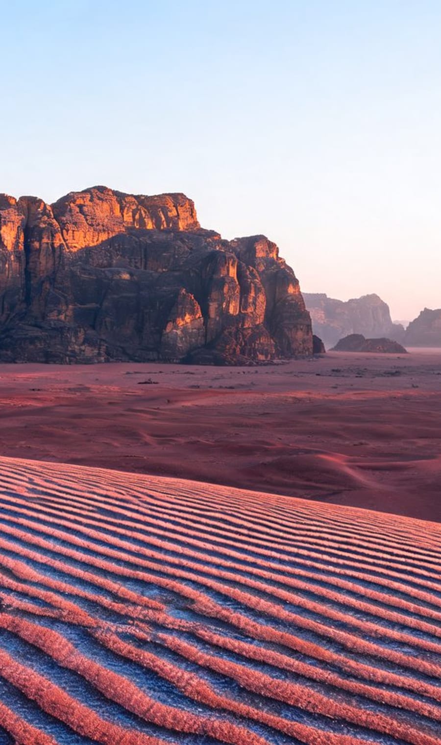 Rippled red sand and sandstone mesas in Wadi Rum, Jordan